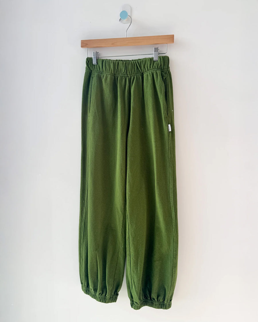 avocado green cotton balloon pants with side pockets on a hanger