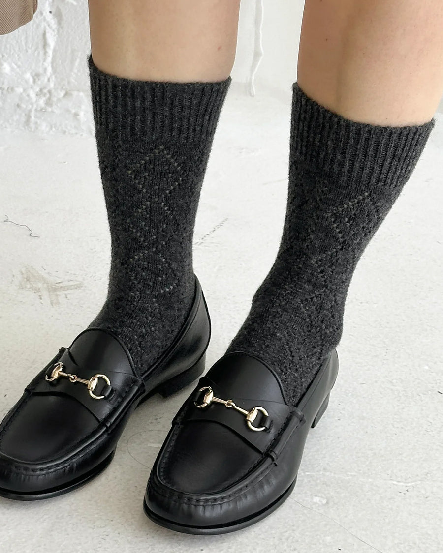 model wearing charcoal pointelle tall crew socks with black loafers