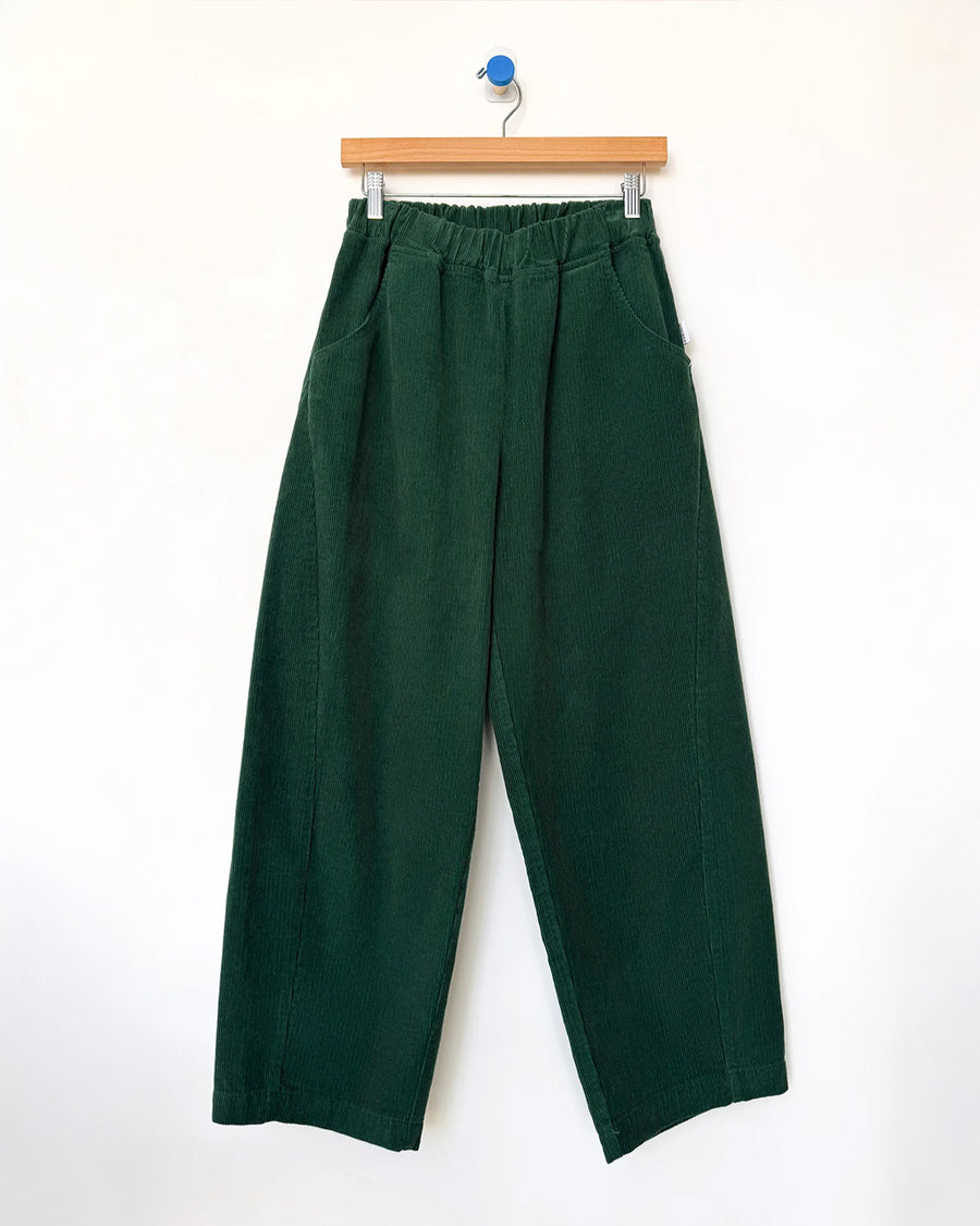 dark green corduroy arc pants with side panels and pockets on a hanger