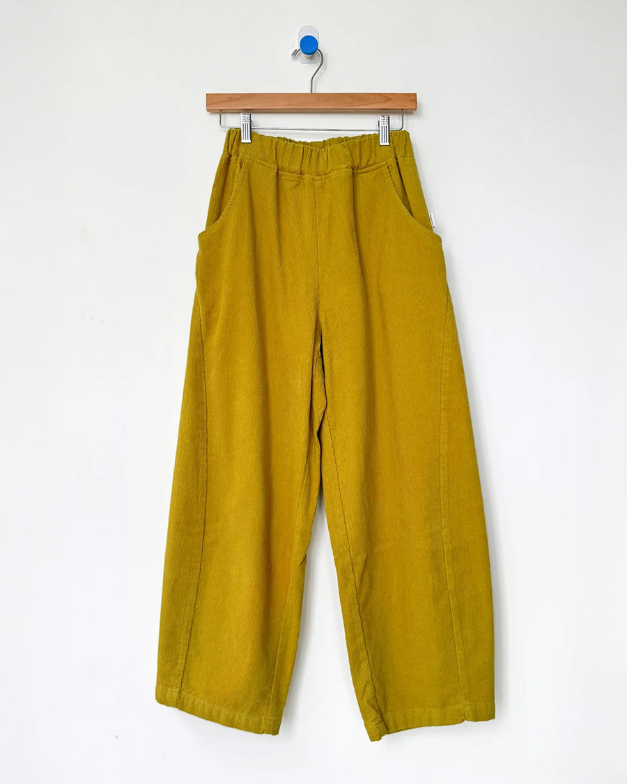 green olive corduroy arc pants with side panels and pockets on a hanger