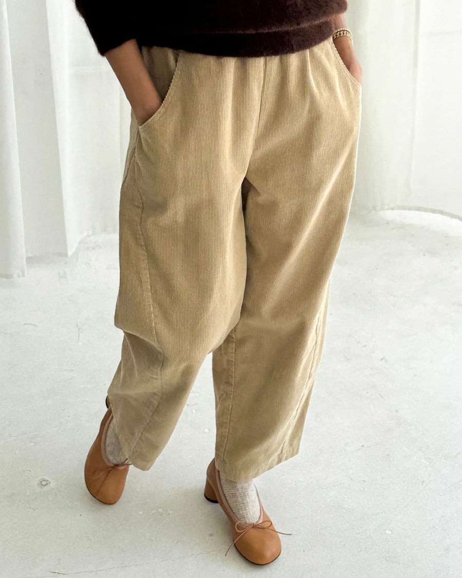 model wearing khaki corduroy arc pants with side panels and pockets