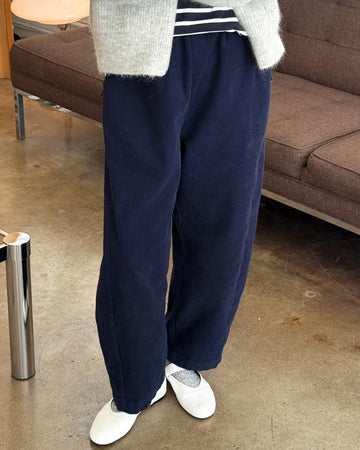 model wearing navy corduroy arc pants with side panels and pockets
