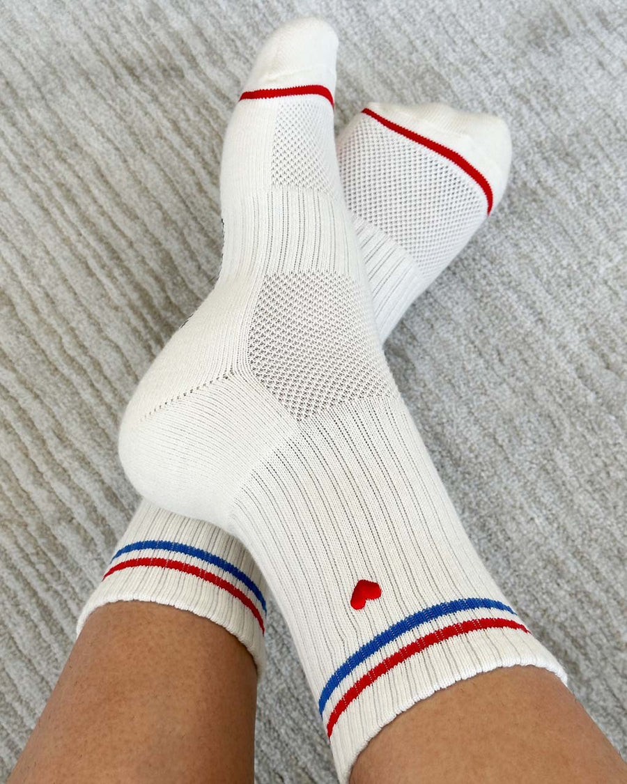 model wearing white socks with red and blue stripe with embroidered red heart