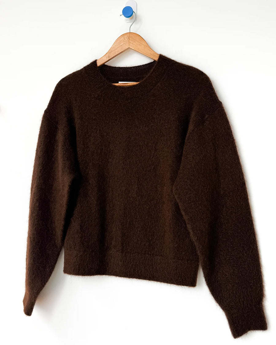 dark brown mohair pull over sweater on a hanger