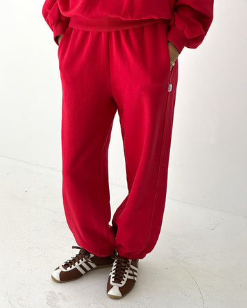 model wearing bright red french terry balloon pants with side pockets and side panels