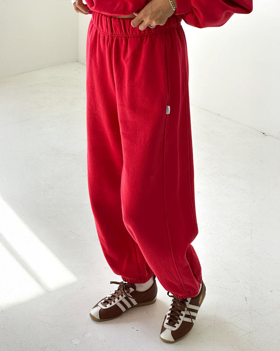 model wearing bright red french terry balloon pants with side pockets and side panels