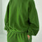 model wearing avocado pull over sweatshirt with slight balloon sleeve and waist band