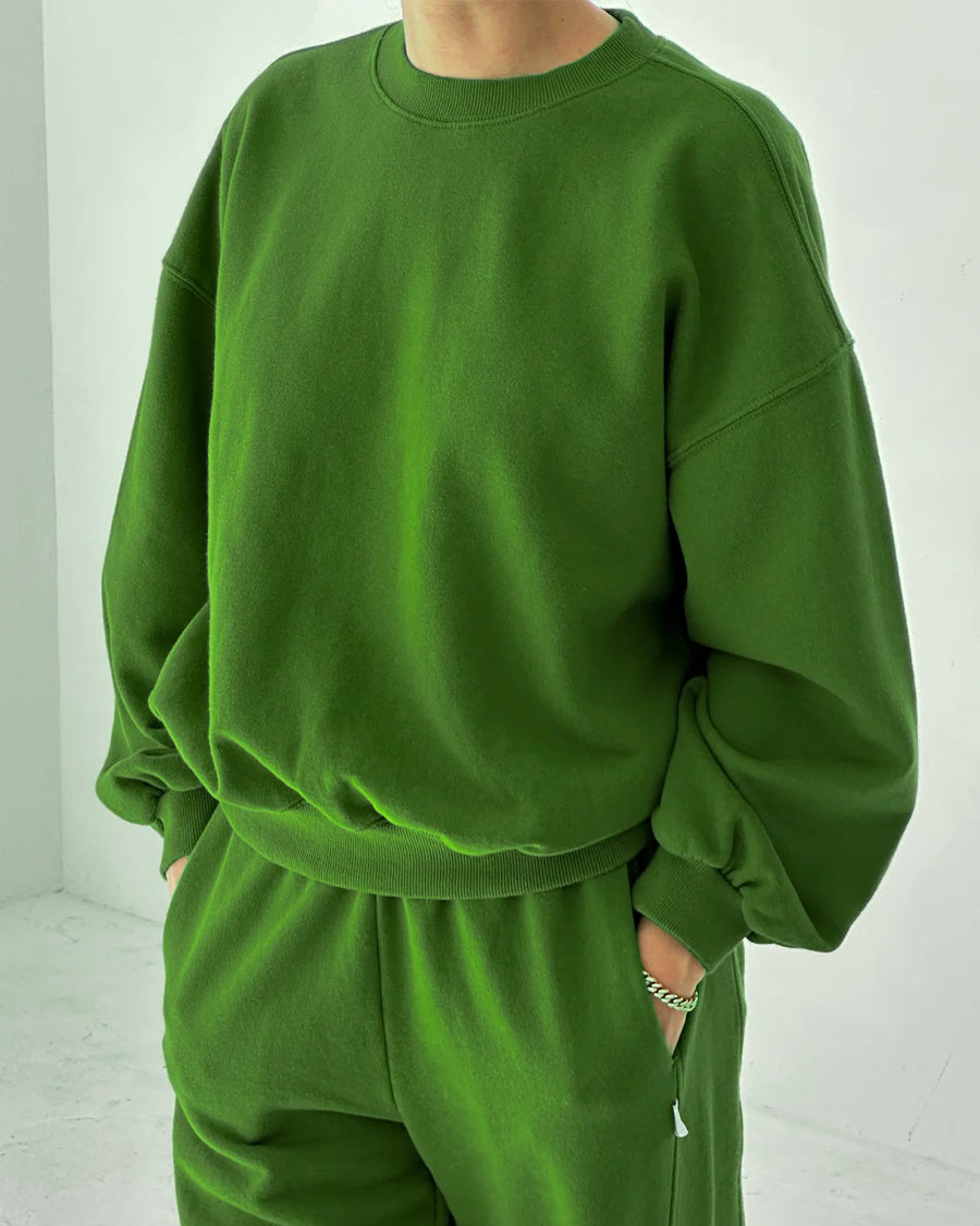 model wearing avocado pull over sweatshirt with slight balloon sleeve and waist band