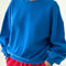 model wearing lagoon blue pull over sweatshirt with slight balloon sleeve and waist band