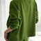 back view of model wearing avocado colored long sleeve tee with elastic wristbands