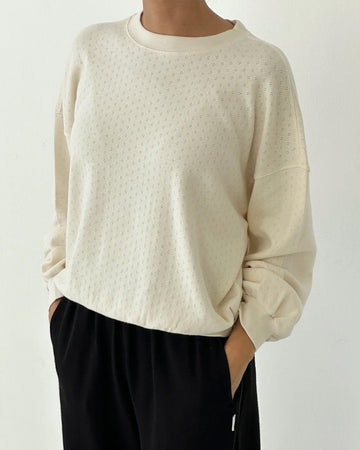 model wearing cream pointelle long sleeve sweatshirt with banded wrists and waist