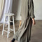 back view of model wearing green heavy cotton maxi dress with side slots and long sleeves
