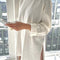 model wearing white cotton tunic top with deep side slits and long sleeves