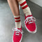 model wearing cream crew socks with two red stripes