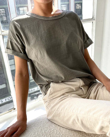 model wearing relaxed, slightly cropped army green tee with distressing on the neckline