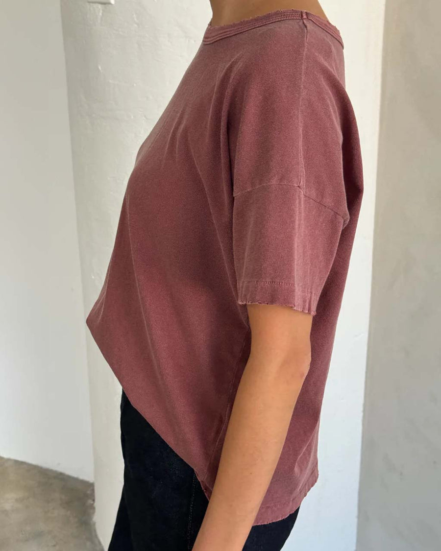 side view of model wearing relaxed, slightly cropped brick tee with distressing on the neckline