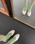 model wearing high green socks with white thin stripes with white flats