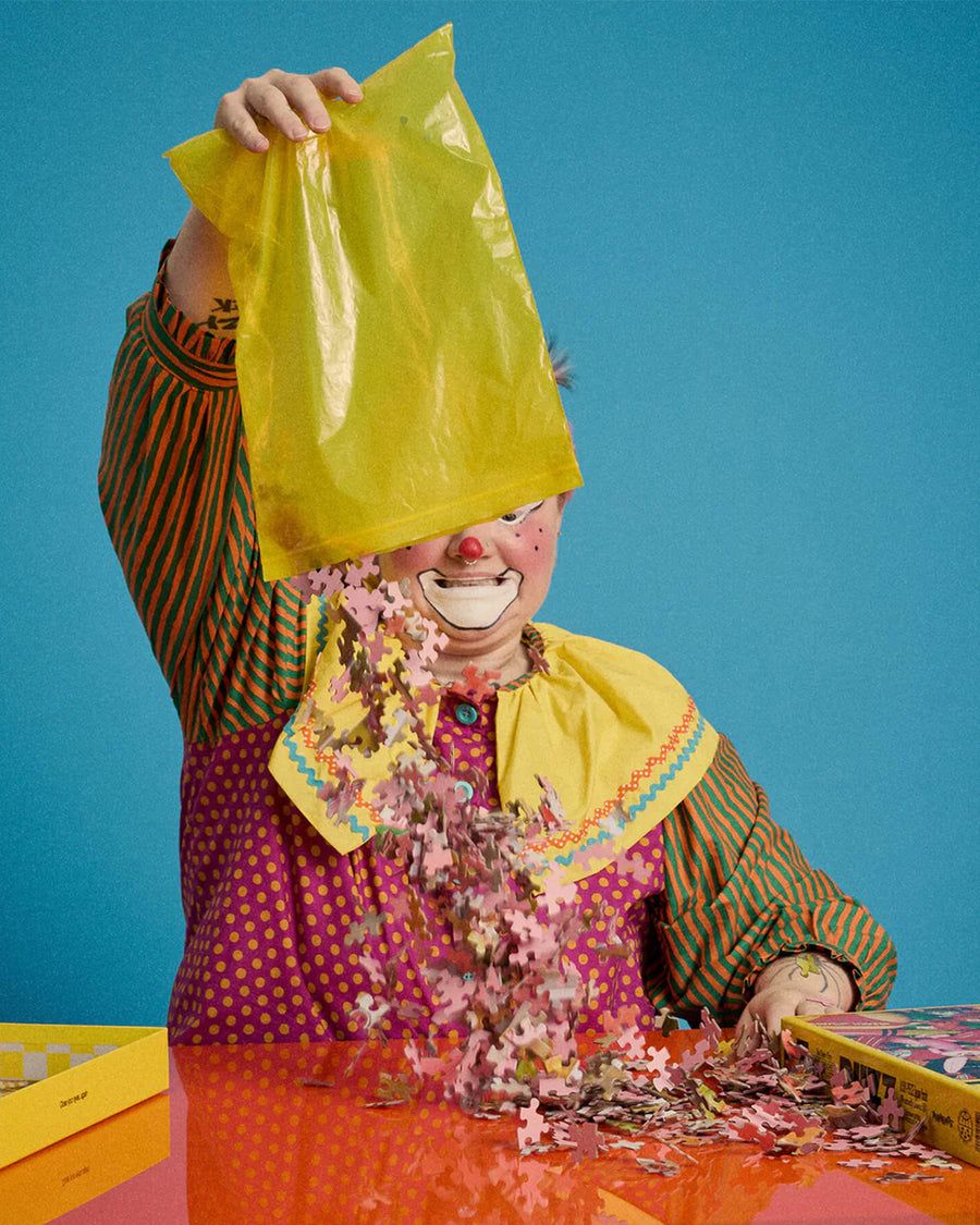 model pouring out pieces of 500 piece puzzle with realistic colorful retro inflatables piled on each other