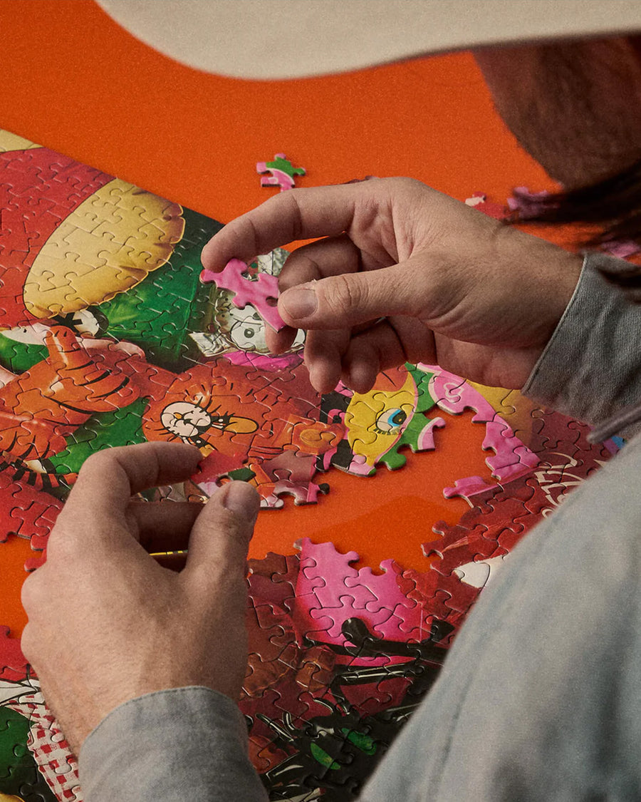 model putting together 500 piece puzzle with realistic colorful retro inflatables piled on each other