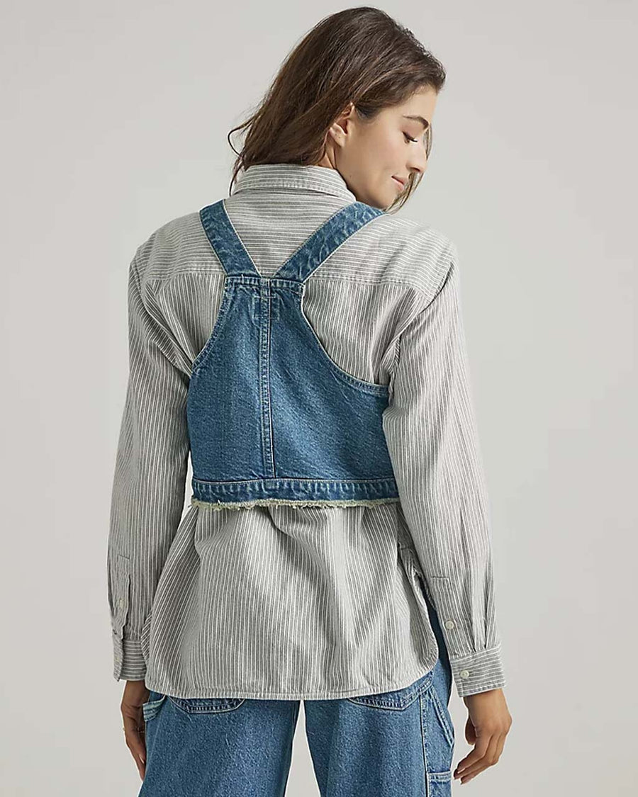 back view of model wearing denim overall bib top with adjustable straps, cropped length and front pocket