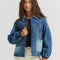 model wearing patched denim chore jacket with a mix of light and dark wash denim and front patch pockets