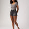 model wearing washed black denim shorts with distressed hems