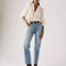 model wearing medium denim slightly relaxed straight leg jeans with cream blouse