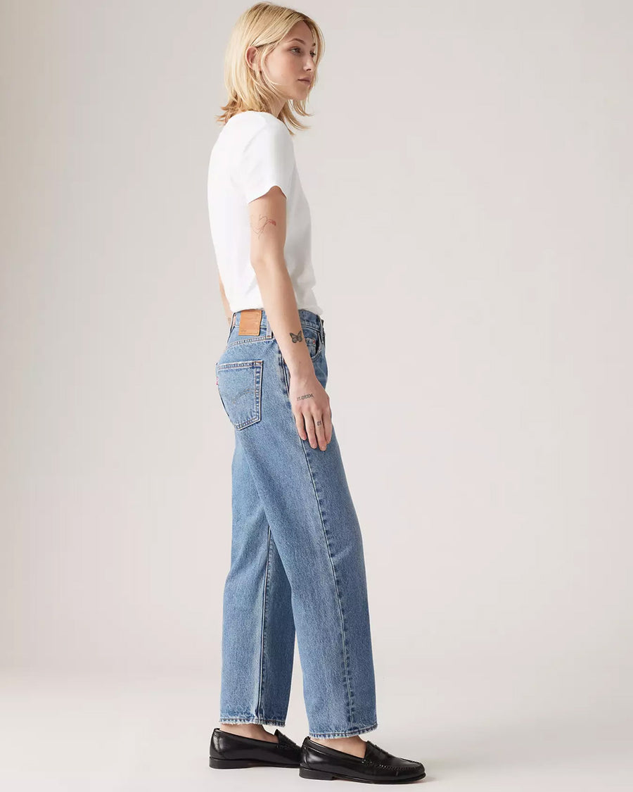 side view of model wearing light denim 90's ankle jeans