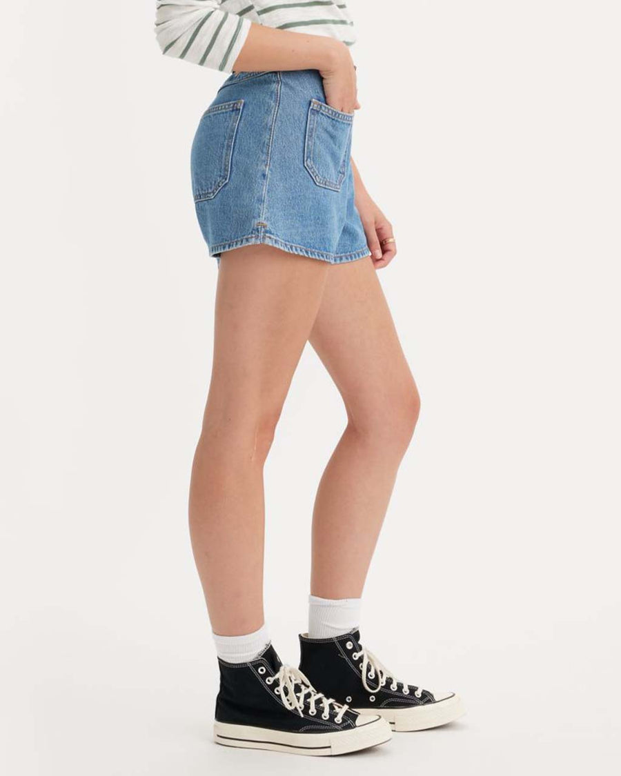 side view of model wearing light denim patch pocket shorts