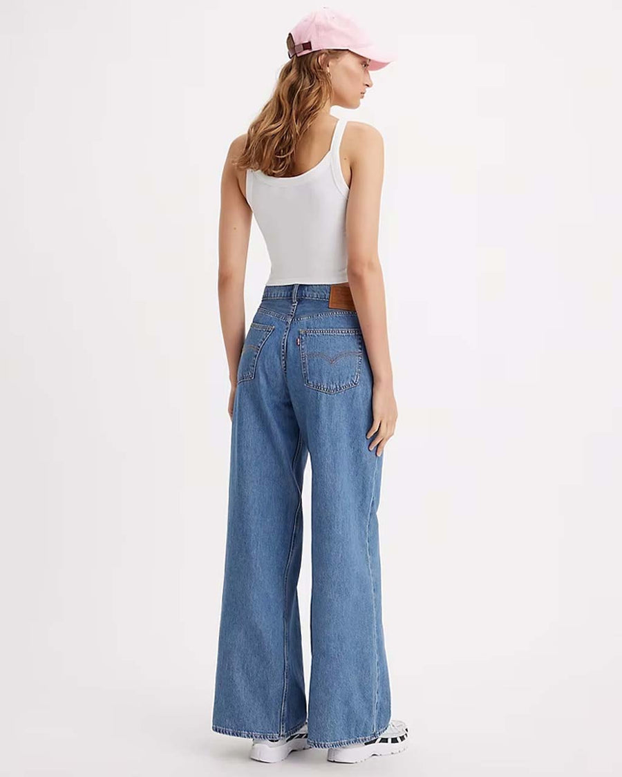 back view of model wearing medium wash denim jeans with oversized baggy look