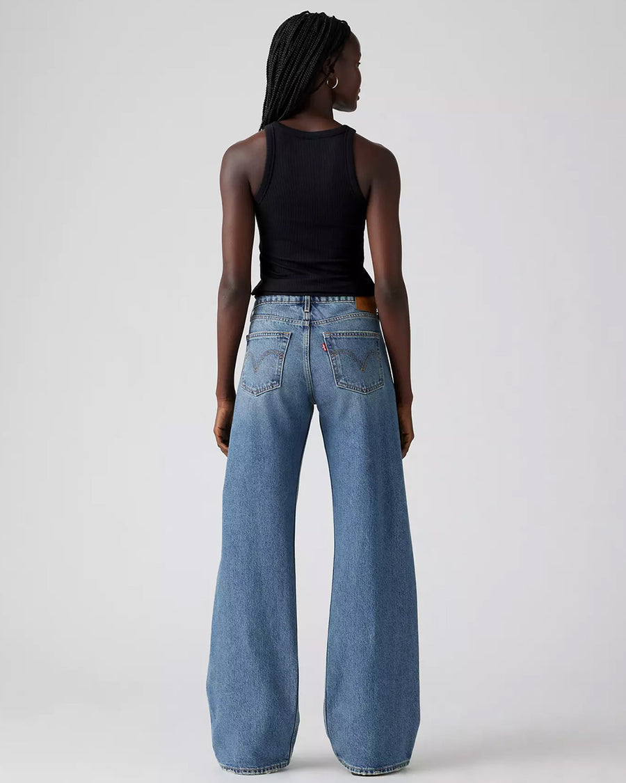 back view of model wearing light denim low loose jeans