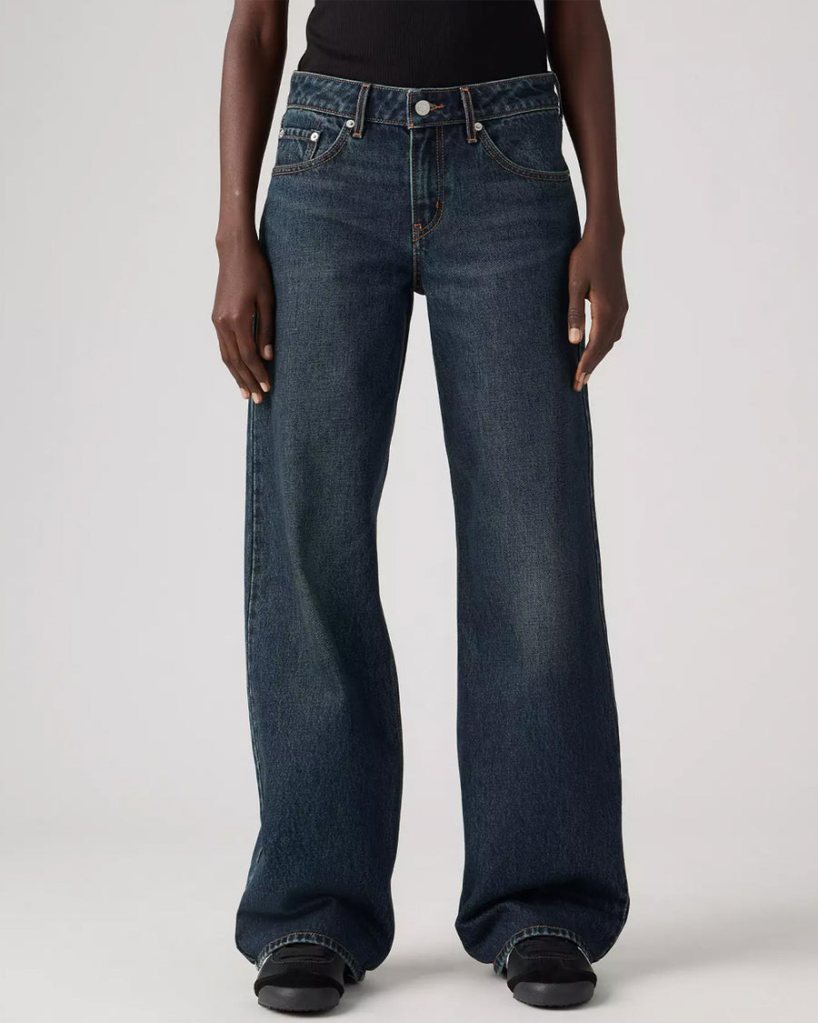 up close of model wearing low rise dark wash denim with a relaxed leg