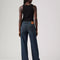 back view of model wearing low rise dark wash denim with a relaxed leg