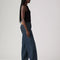 sideview of model wearing low rise dark wash denim with a relaxed leg