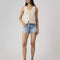 model wearing light denim low rise shorts with distressed hem