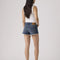 back view of model wearing dark denim low rise shorts with frayed hem