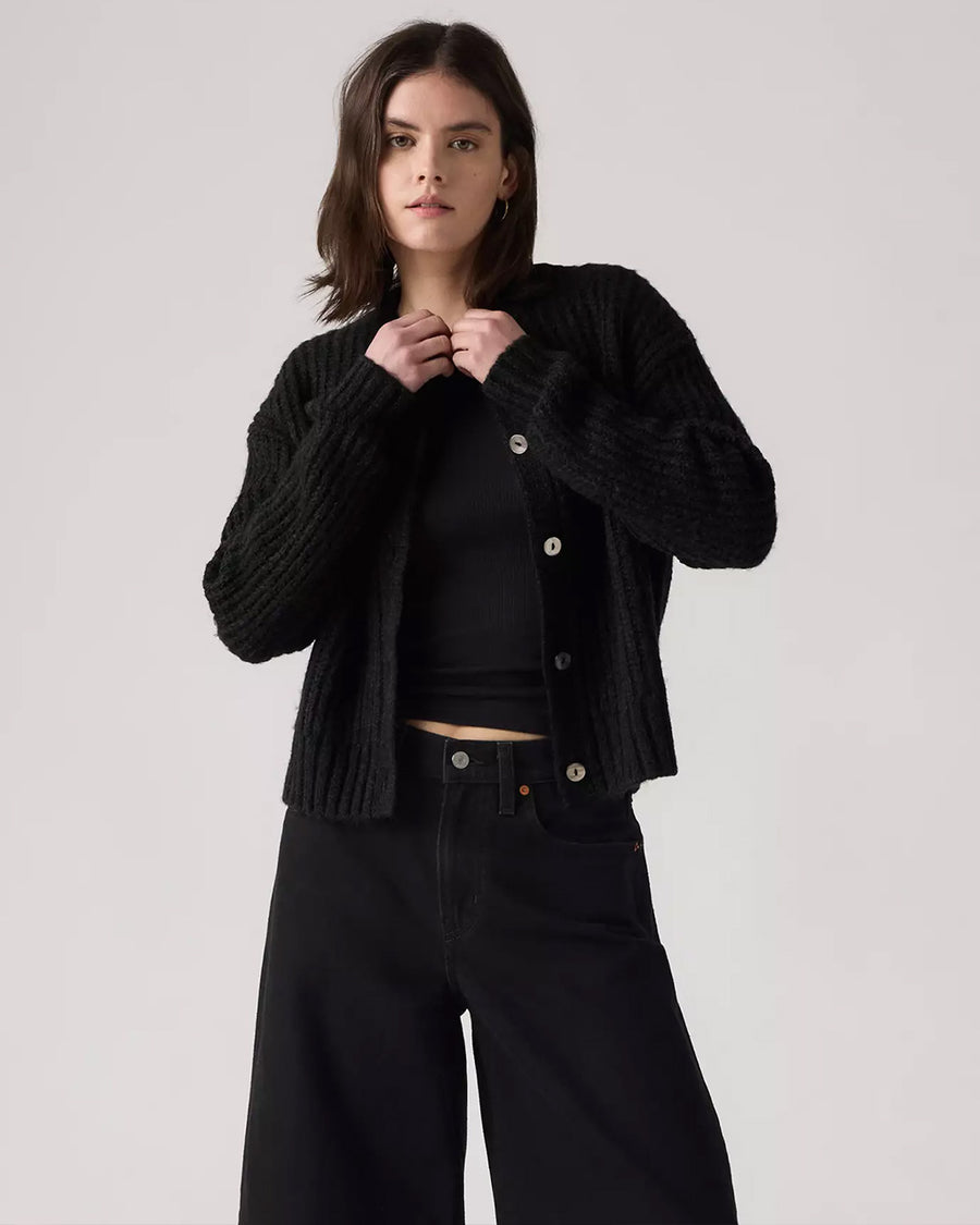 model wearing black textured cardigan with shell buttons