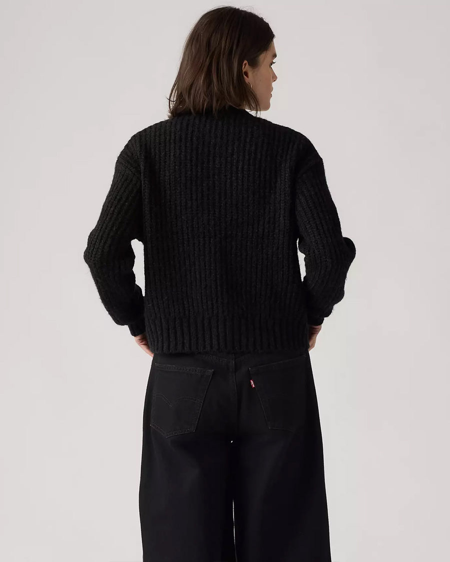back view of model wearing black textured cardigan with shell buttons