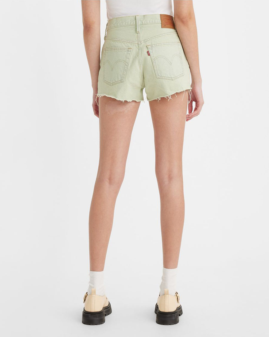 backview of model wearing green raw hem shorts