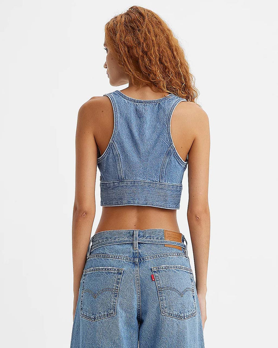 back view of model wearing cropped denim sleeves top with deep V neckline and two button closure