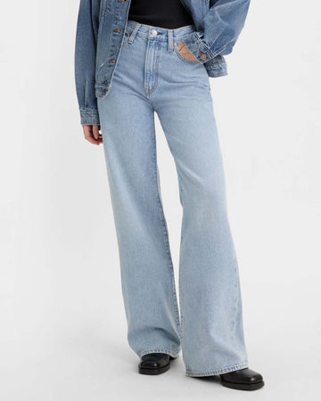 model wearing light denim wide leg jeans