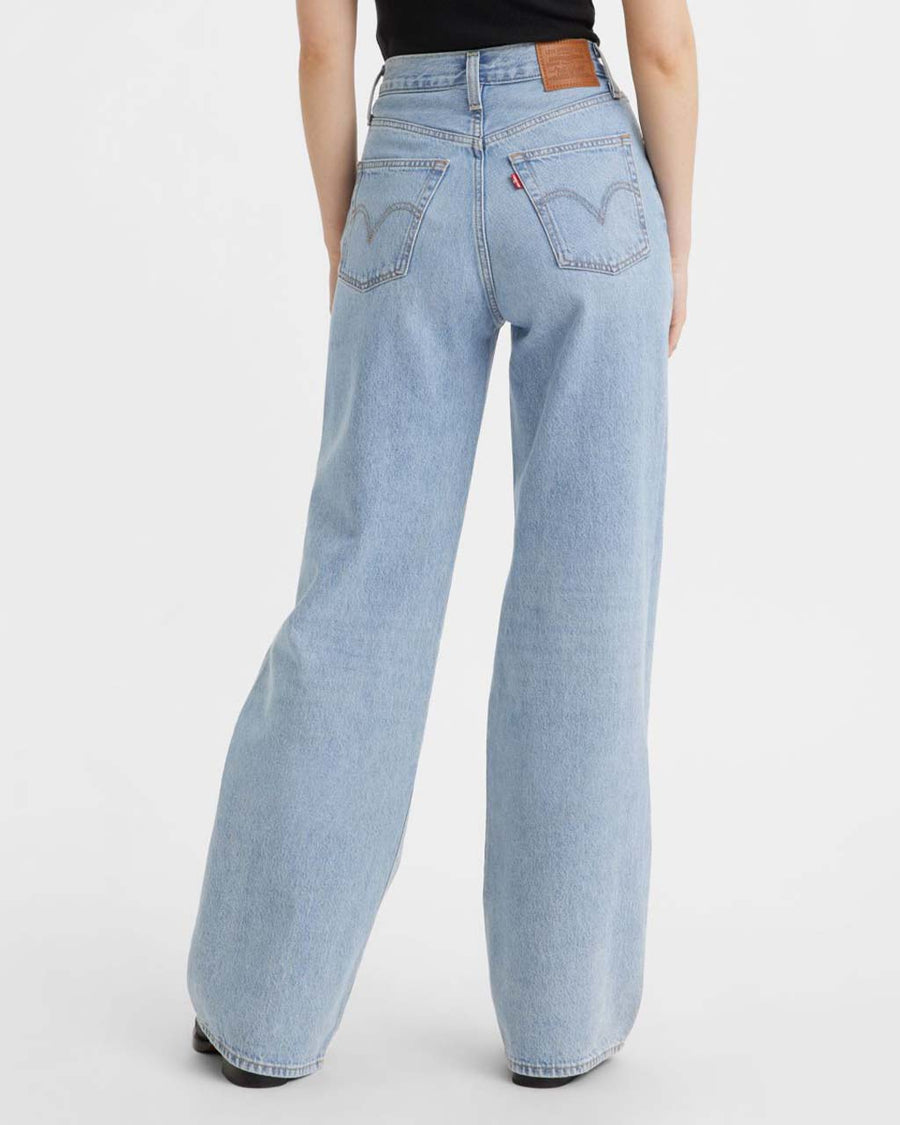 back view of model wearing light denim wide leg jeans