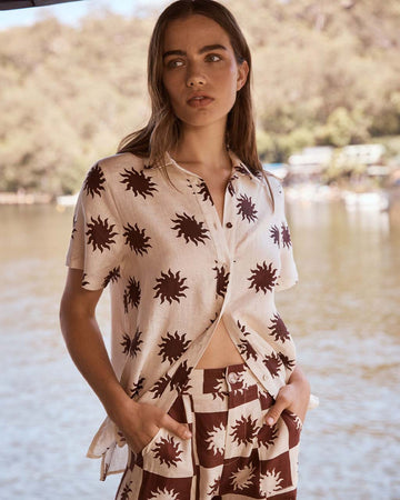 model wearing white linen button down top with sun print with matching sun pants