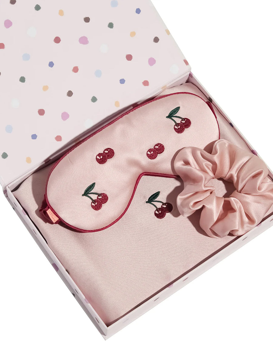 light pink mulberry silk eye mask with embroidered all over cherry print and pink pillowcase with dainty embroidered cherries on the center and pink scrunchie in a cute gift box