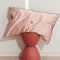 pink mulberry silk pillowcase with  embroidered cherries in the center on a table