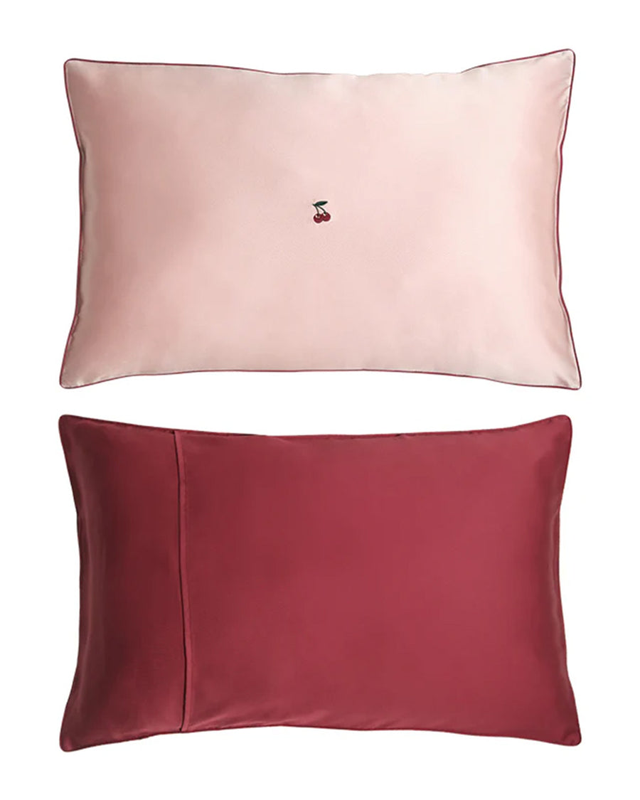 pink mulberry silk pillowcase with  embroidered cherries in the center and red backing on the reverse side