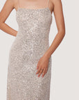 up close of model wearing thin strap silver sequin midi dress with back cutout