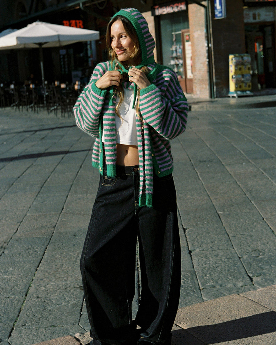model wearing pink and green thin striped bonnet and matching scarf and cardigan
