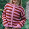 model wearing textured cardigan with red and pink horizontal stripes