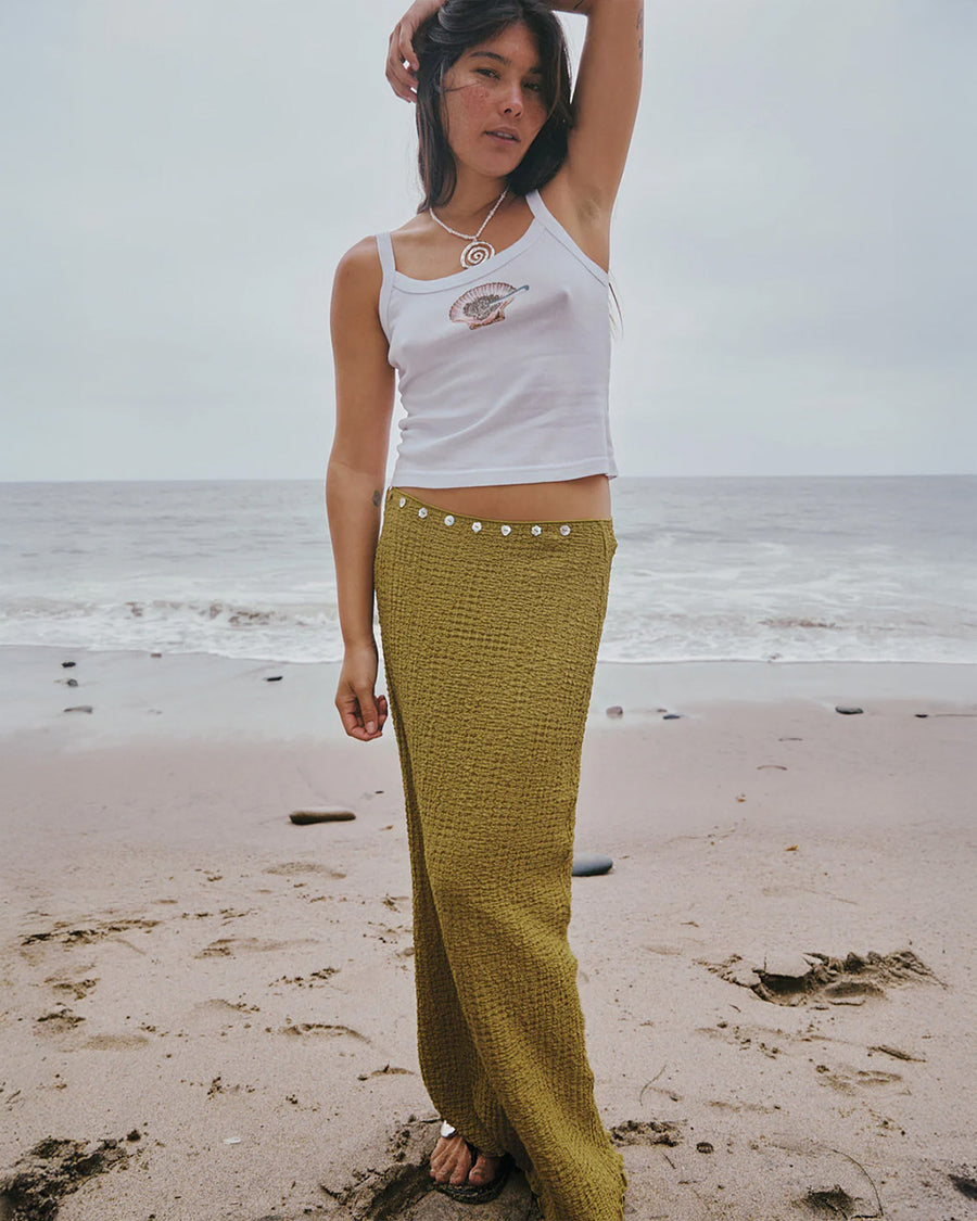 model wearing olive crinkle midi skirt with shaped shell buttons on the top with a white tank